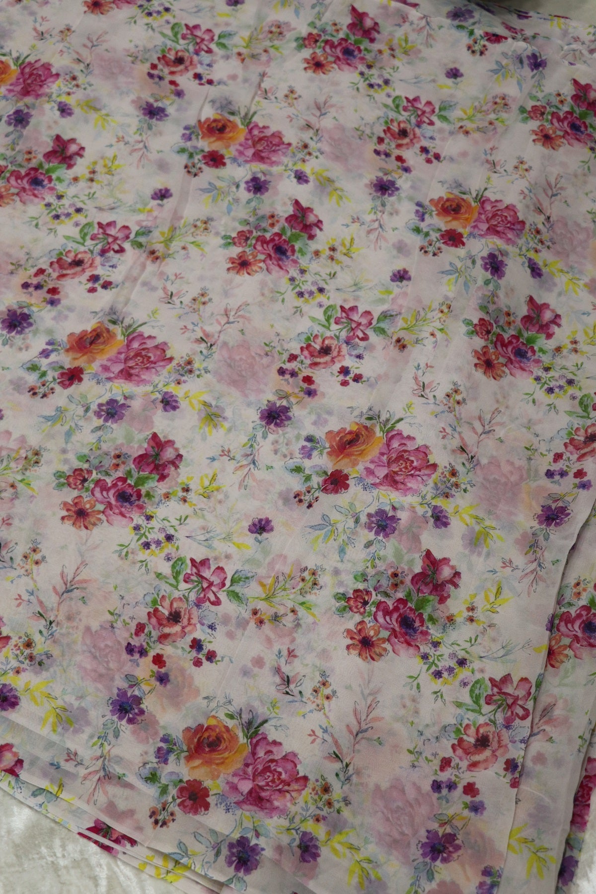White Printed Georgette Fabric With Hues Of Pink & Oran0ge Flowers